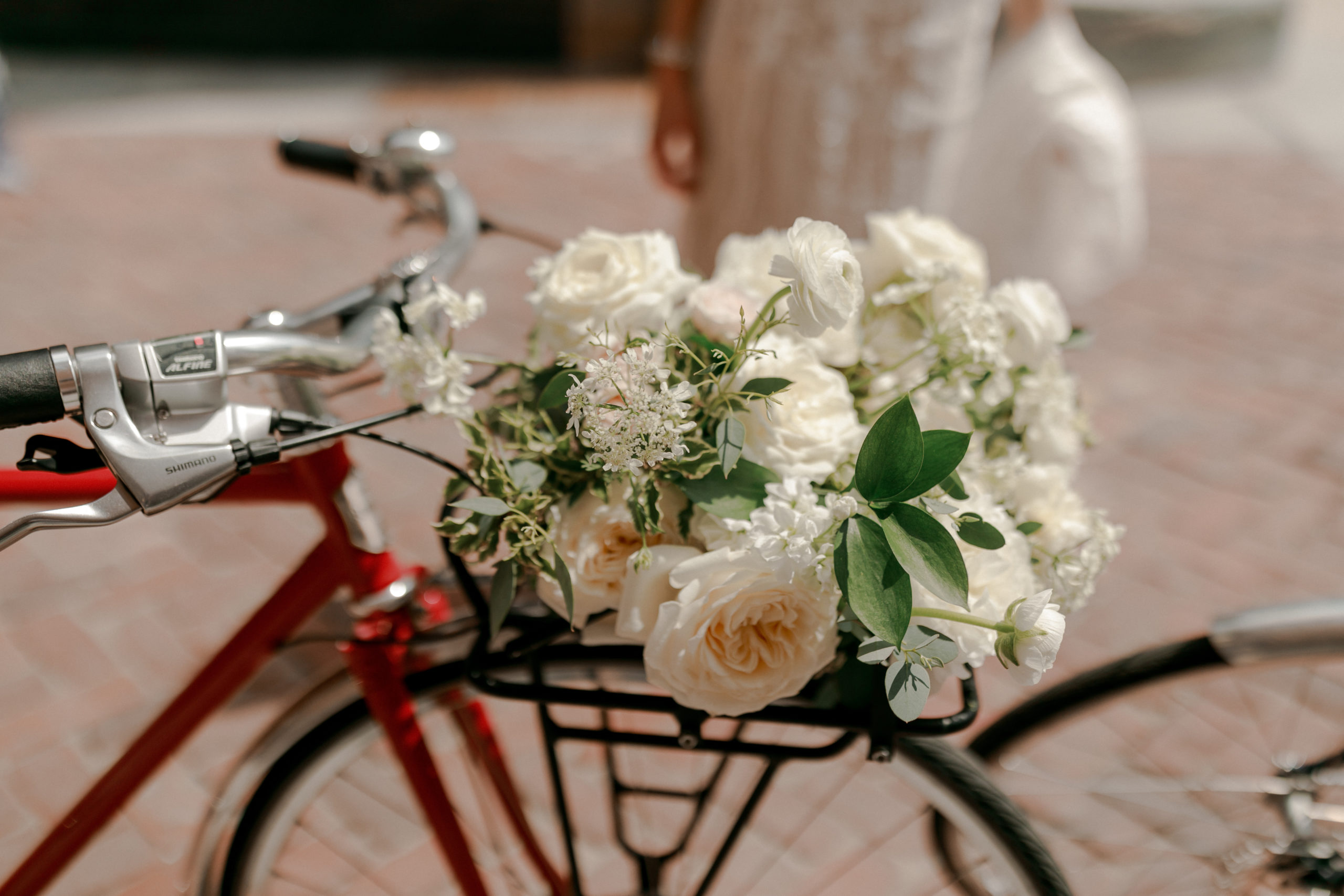 white bouquet in a bike basket 